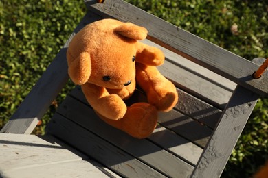 Photo of Lonely teddy bear on swing in park, above view