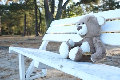 Photo of Lonely teddy bear on bench in park