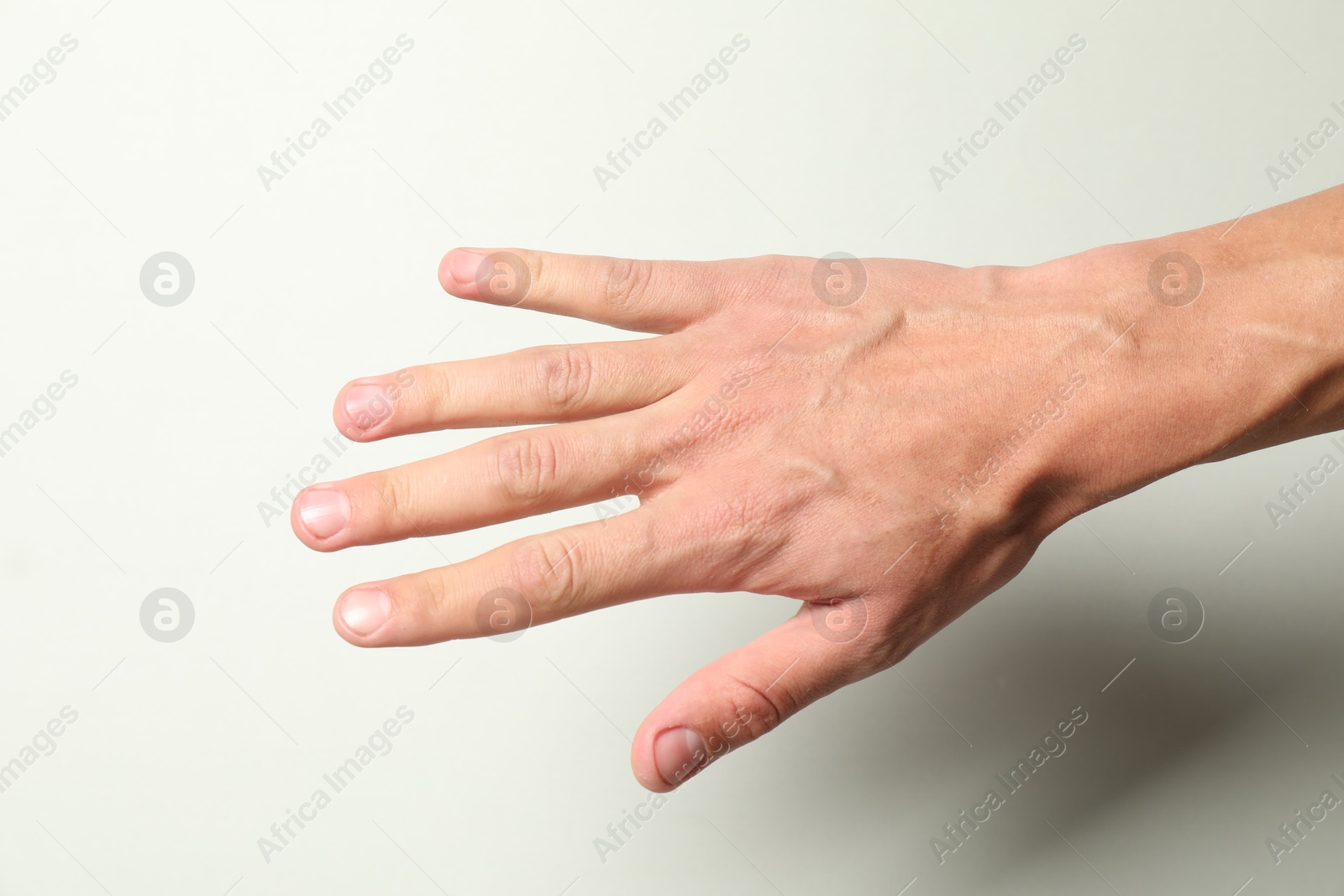 Photo of Man with bulging veins on his arm against light background, closeup