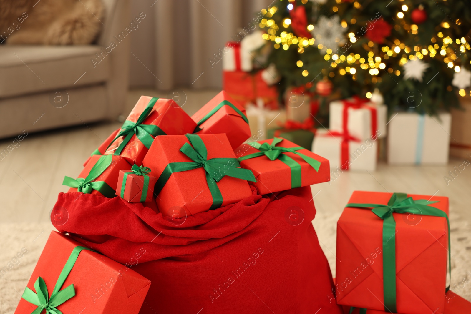 Photo of Santa bag full of Christmas presents at home, closeup