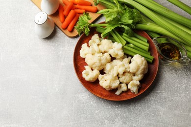 Photo of Tasty cauliflower with celery on grey table, flat lay. Space for text