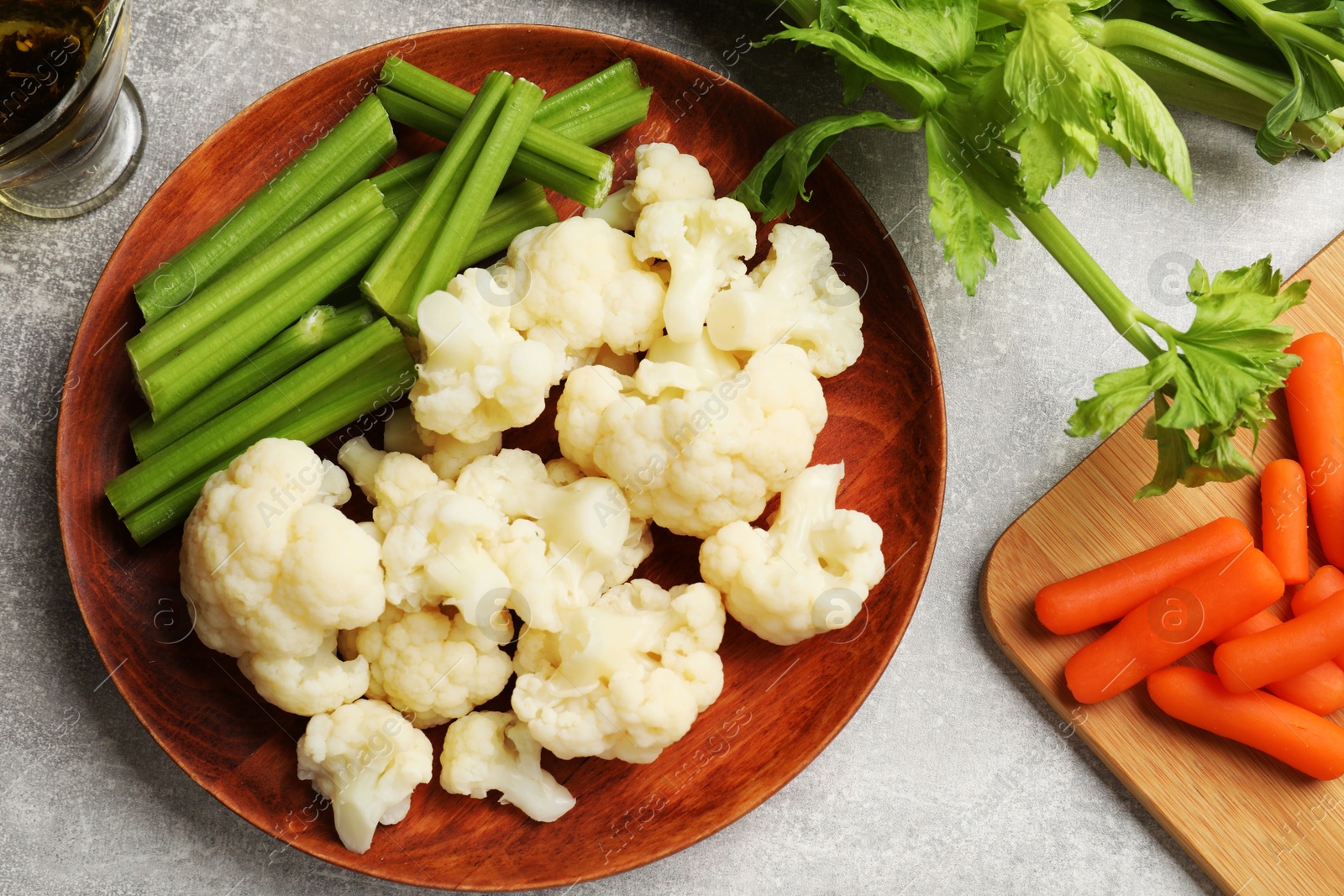 Photo of Tasty cauliflower with celery on grey table, flat lay