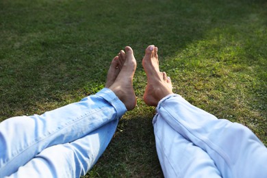 Couple spending time together on green lawn in park, closeup