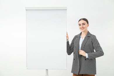 Happy woman near flip chart on white background. Mockup for design