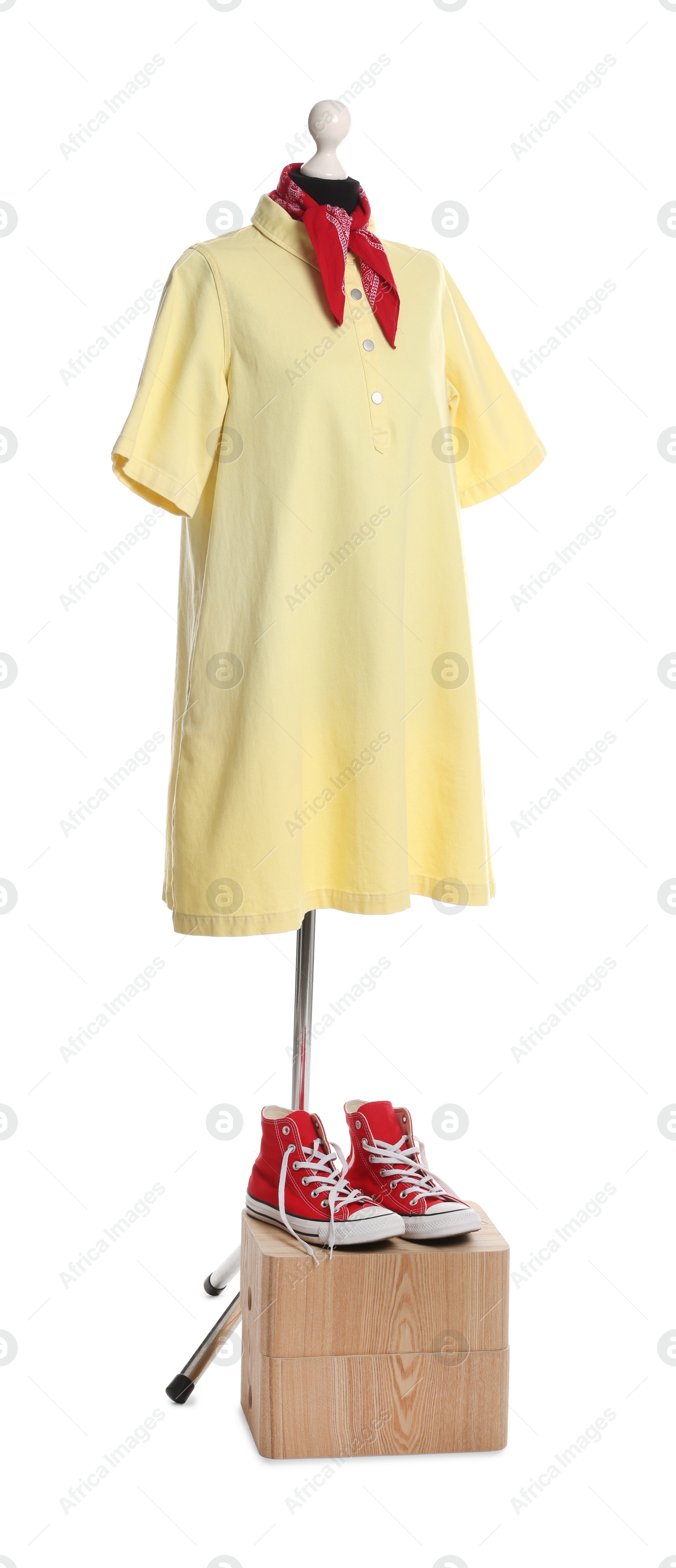 Photo of Female mannequin with stylish yellow dress, handkerchief and red sneakers isolated on white