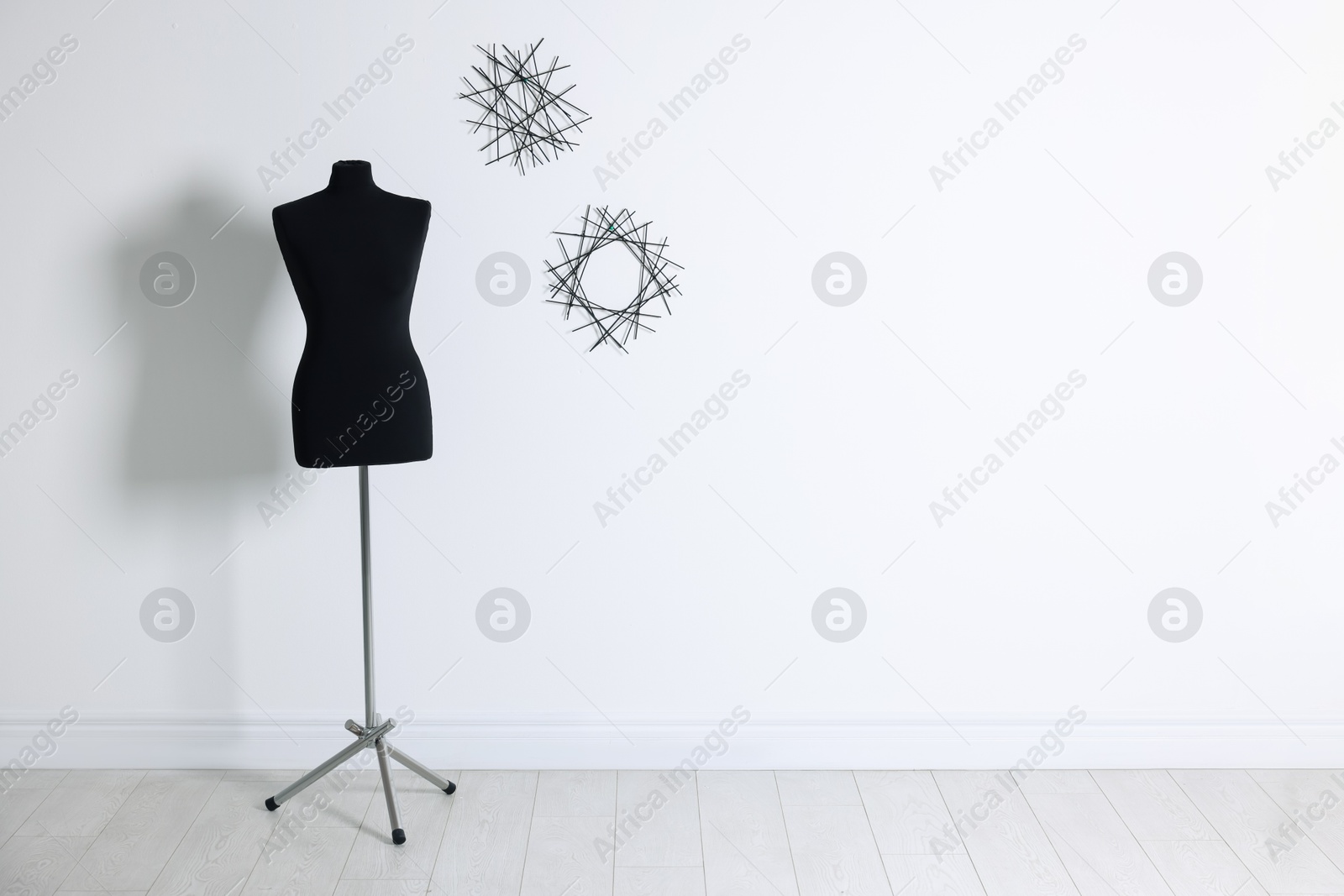 Photo of One black female mannequin near light wall, space for text