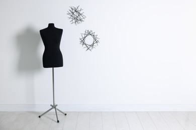 Photo of One black female mannequin near light wall, space for text