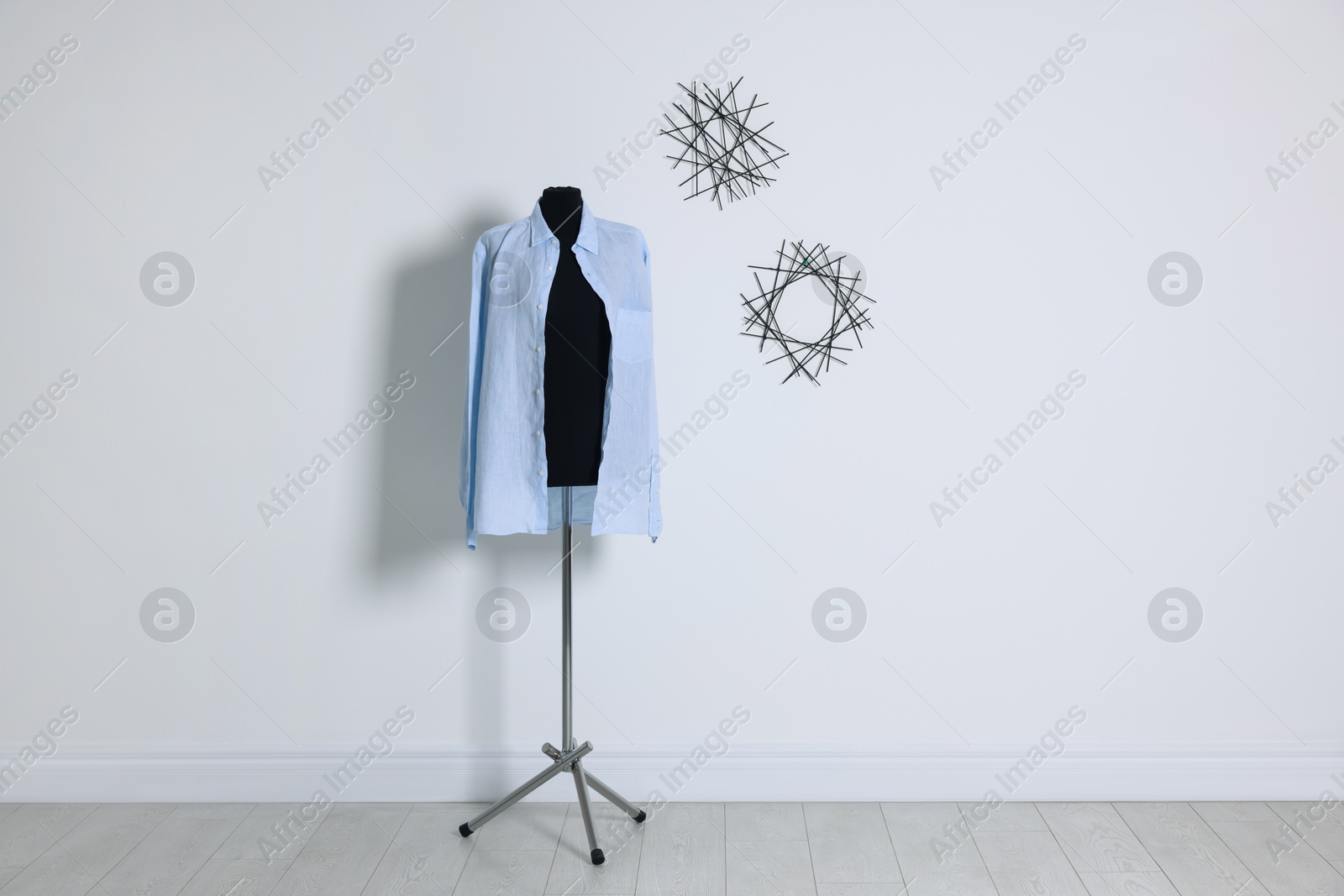 Photo of Female mannequin with stylish shirt near light wall