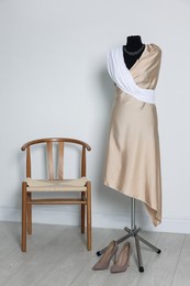 Photo of Female mannequin with draping and shoes in designer's workshop