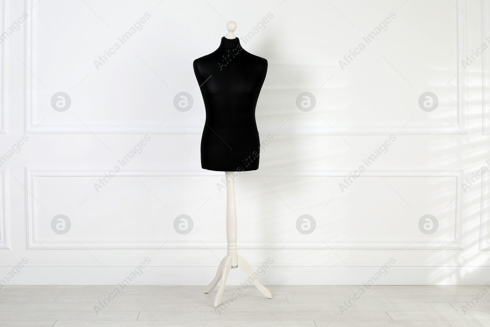 Photo of One black female mannequin near light wall