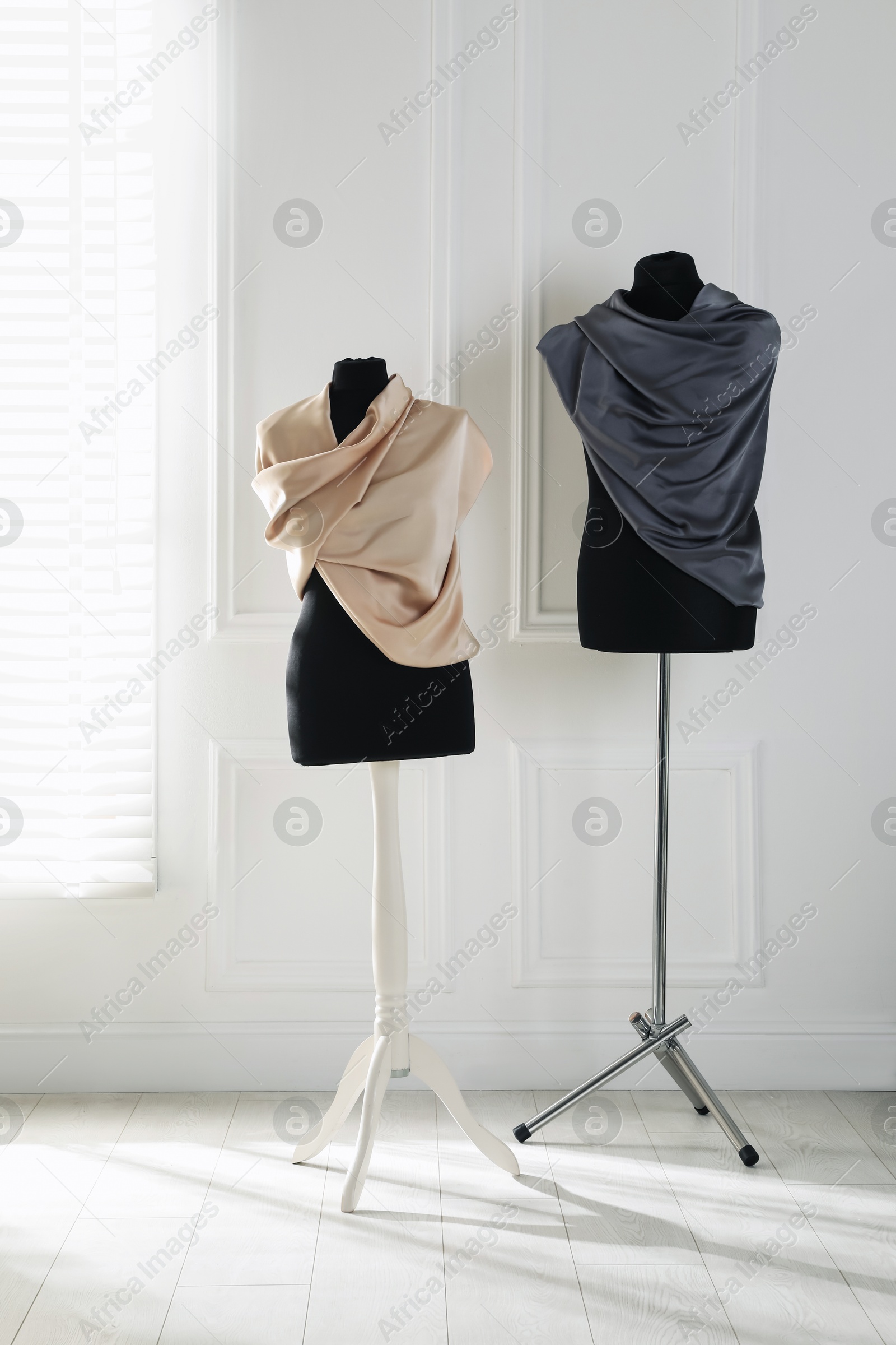 Photo of Female mannequins wrapped in fabric near light wall