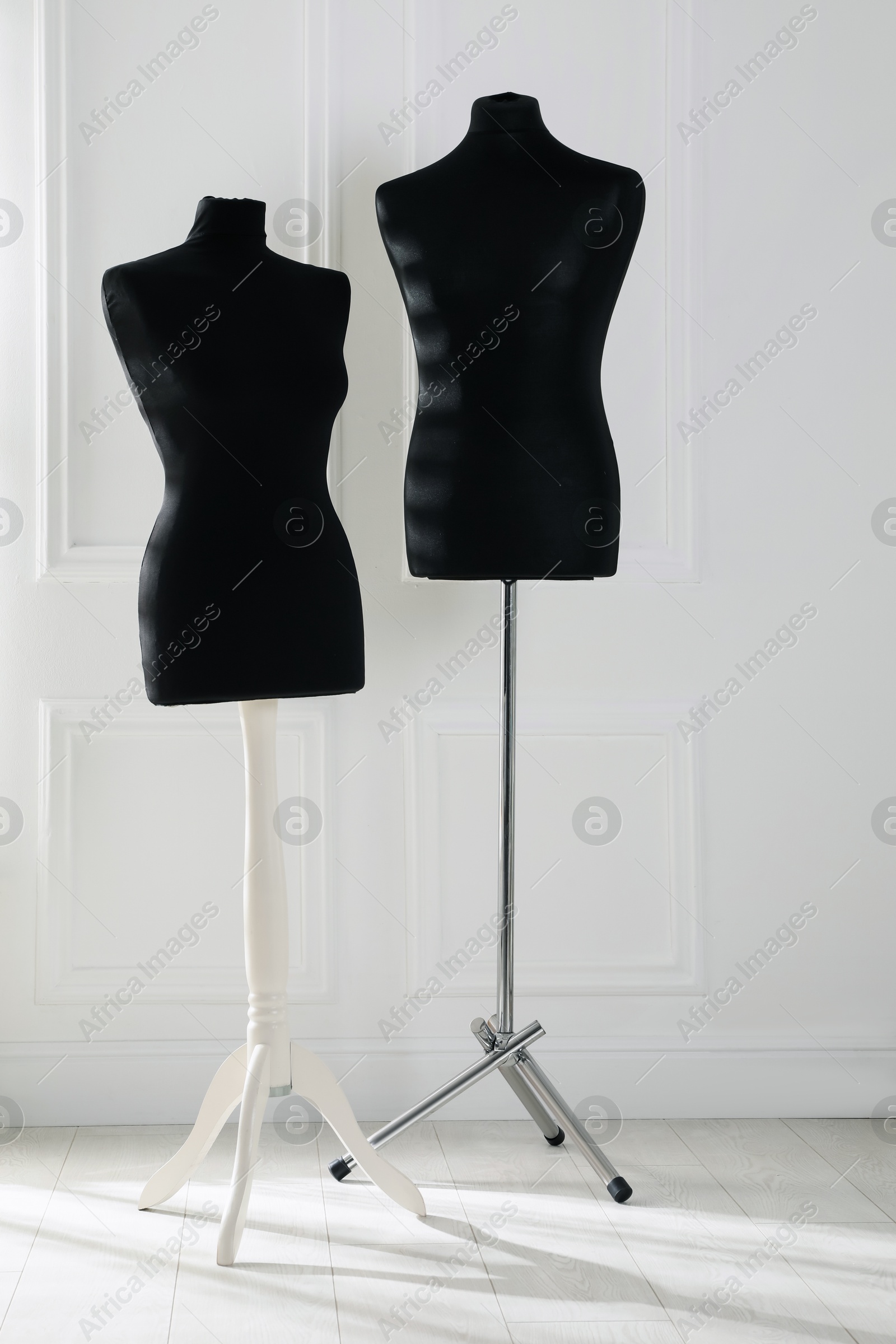 Photo of Two black female mannequins near light wall