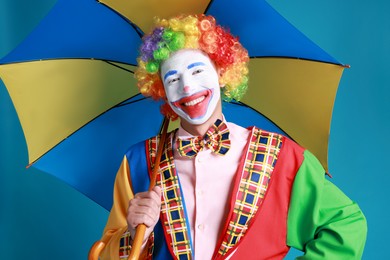 Clown with colorful umbrella on blue background