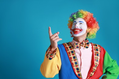 Photo of Portrait of happy clown on blue background, space for text