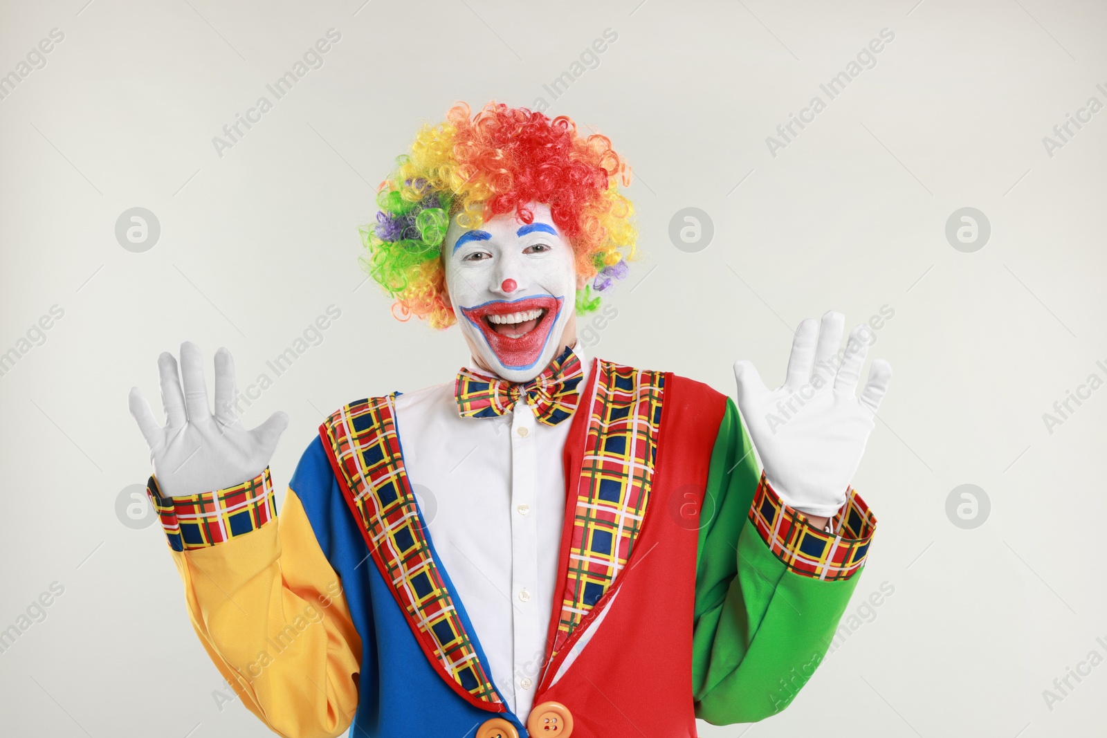 Photo of Portrait of happy clown on light background