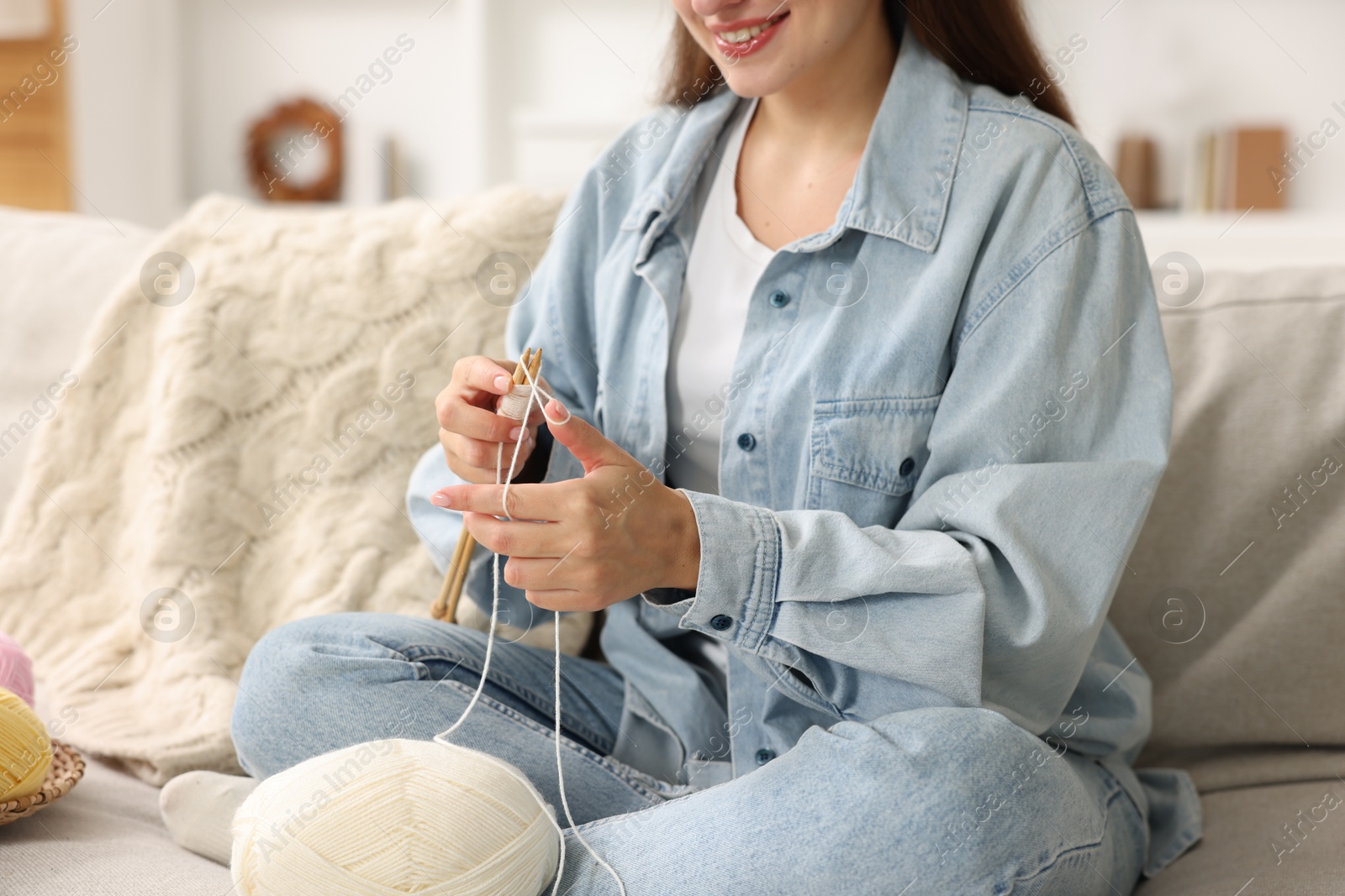 Photo of Woman knitting on sofa at home, closeup