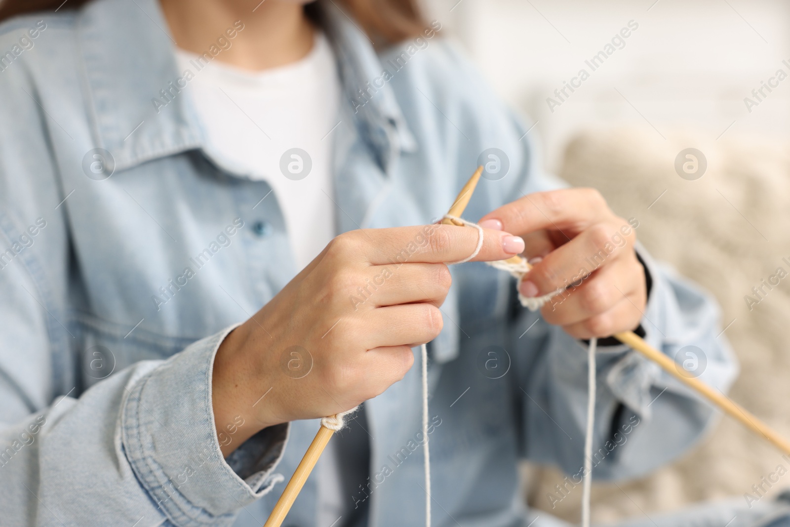 Photo of Woman knitting with needles at home, closeup