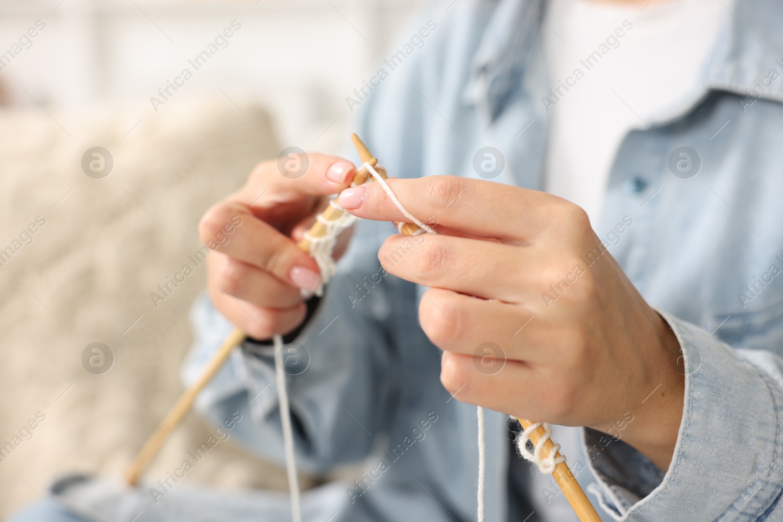 Photo of Woman knitting with needles at home, closeup