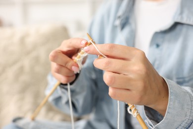 Woman knitting with needles at home, closeup