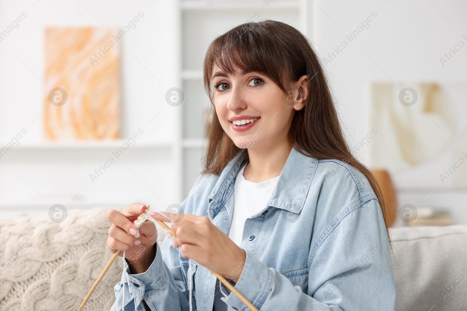 Photo of Beautiful woman knitting with needles at home