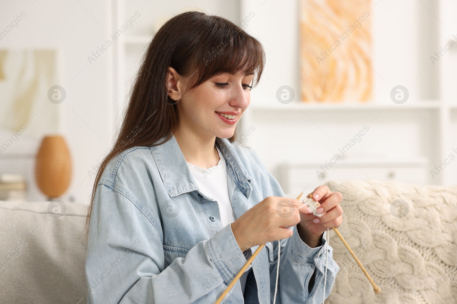 Photo of Beautiful woman knitting with needles at home