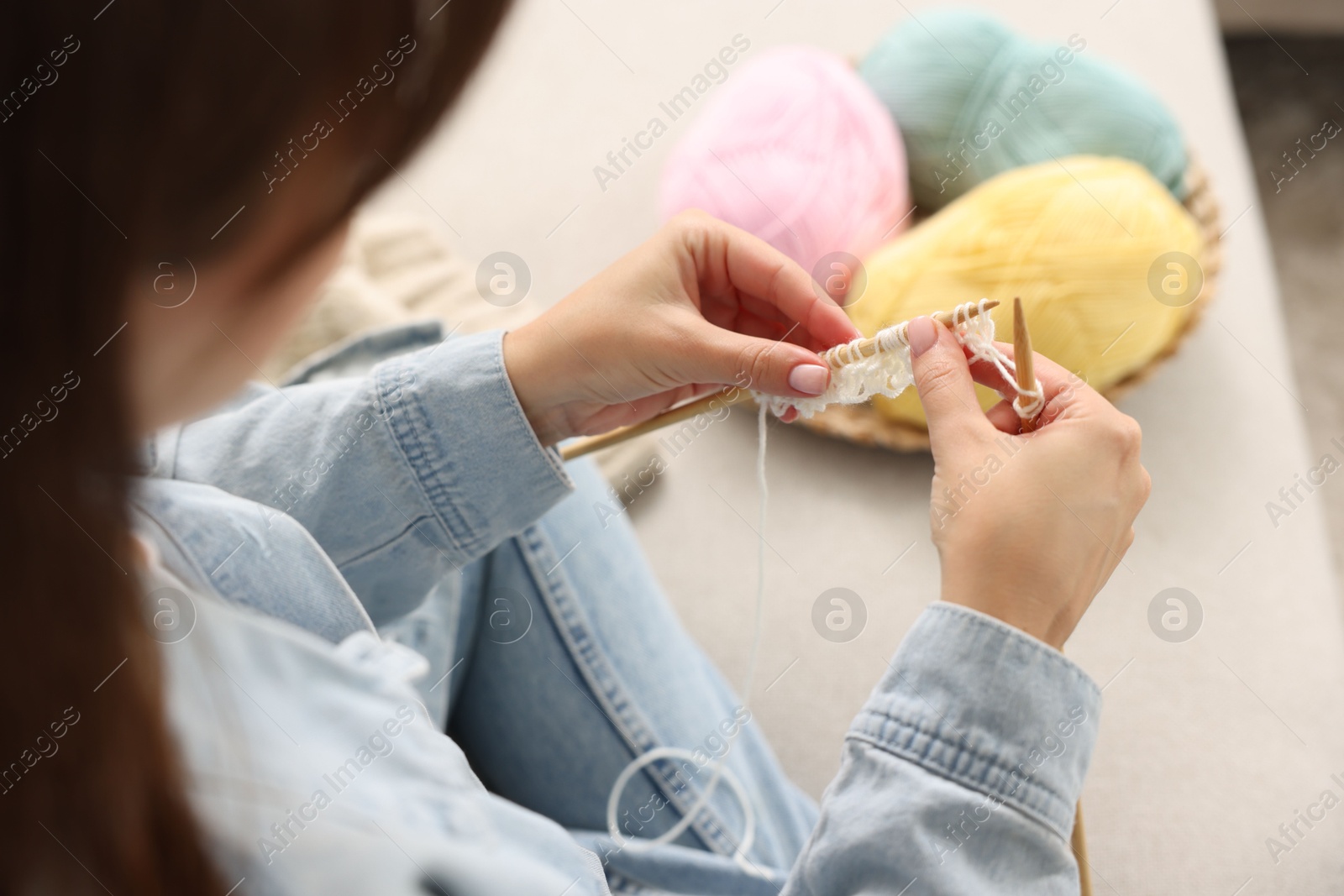 Photo of Woman knitting on sofa at home, closeup