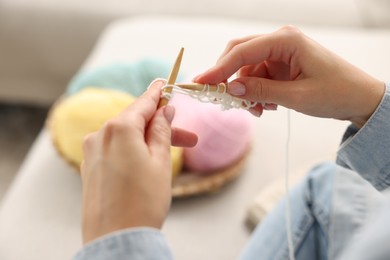 Photo of Woman knitting with needles at home, closeup