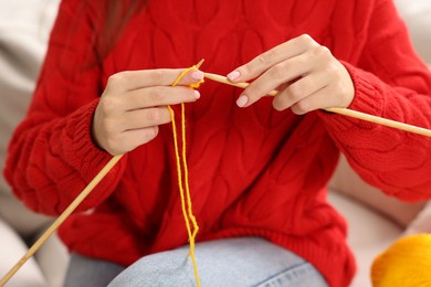 Woman knitting with needles at home, closeup