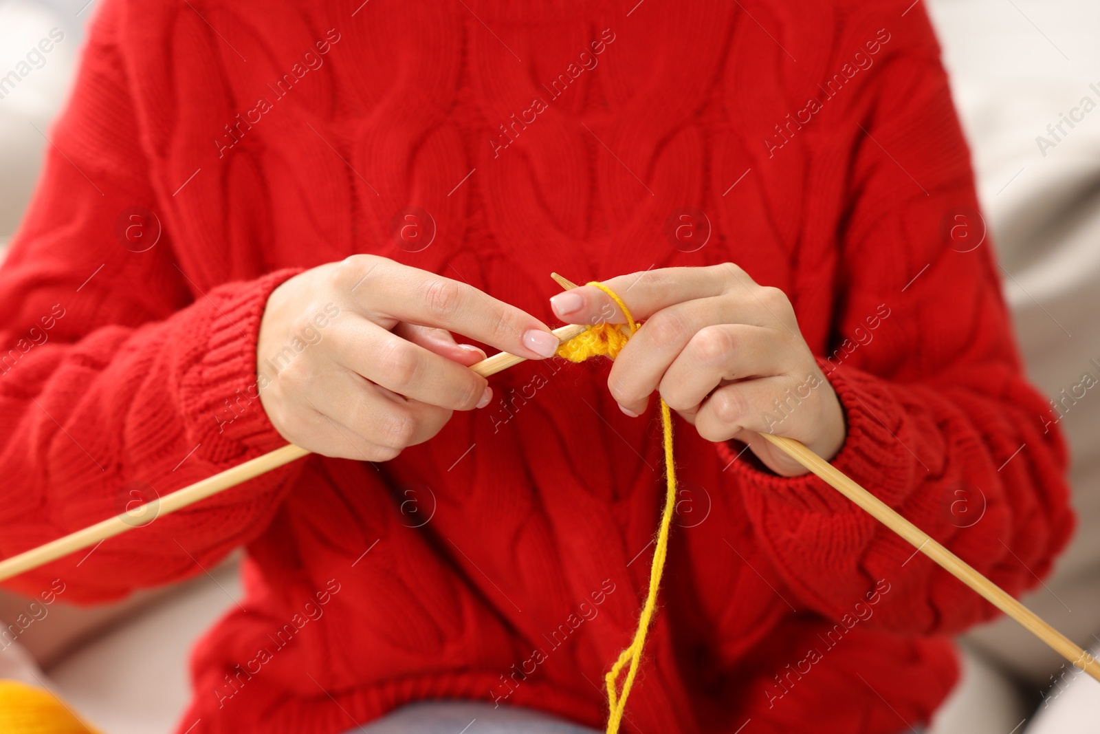 Photo of Woman knitting with needles at home, closeup