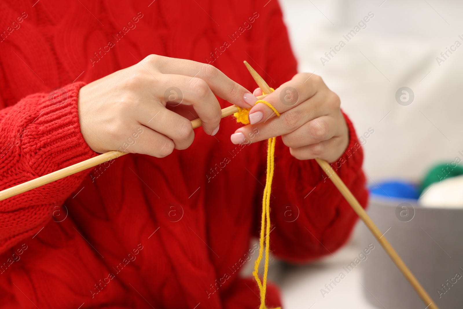 Photo of Woman knitting with needles at home, closeup