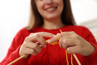 Photo of Woman knitting with needles at home, closeup