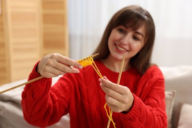 Photo of Beautiful woman knitting at home, selective focus