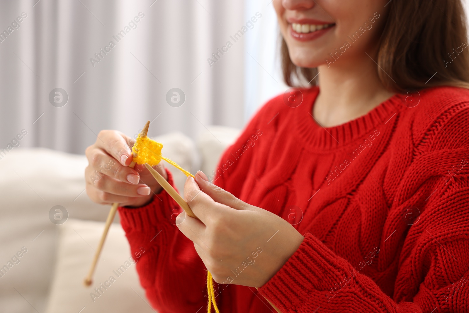 Photo of Woman knitting with needles at home, closeup