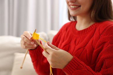 Woman knitting with needles at home, closeup