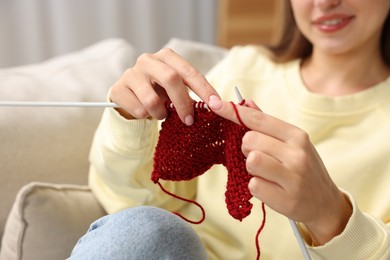 Woman knitting with needles at home, closeup