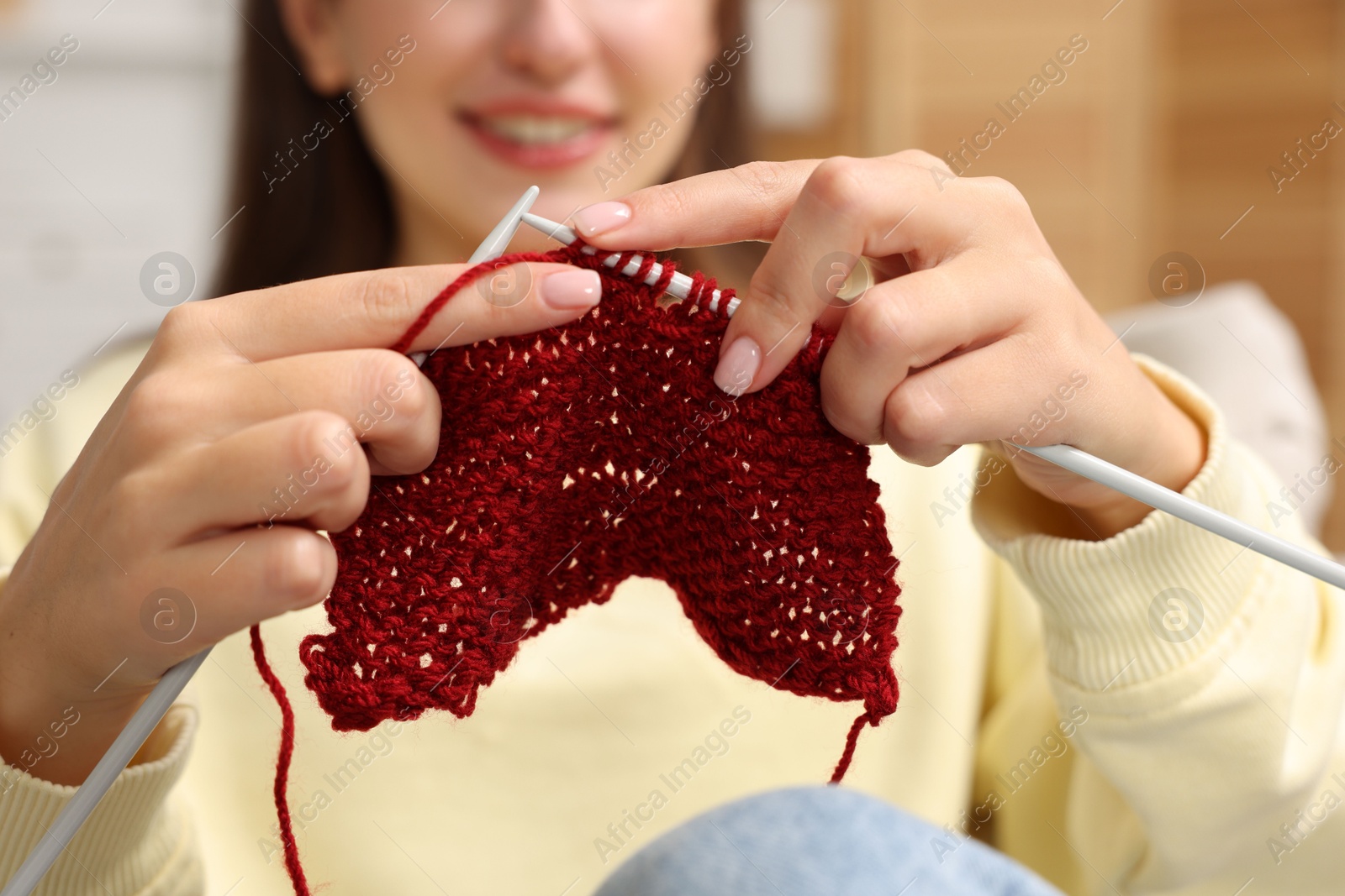 Photo of Woman knitting with needles at home, closeup