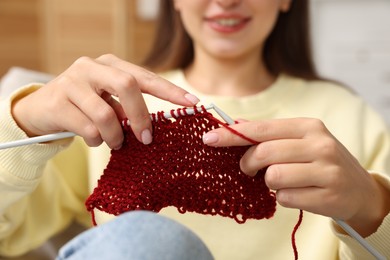 Woman knitting with needles at home, closeup