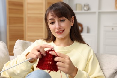 Beautiful woman knitting with needles at home