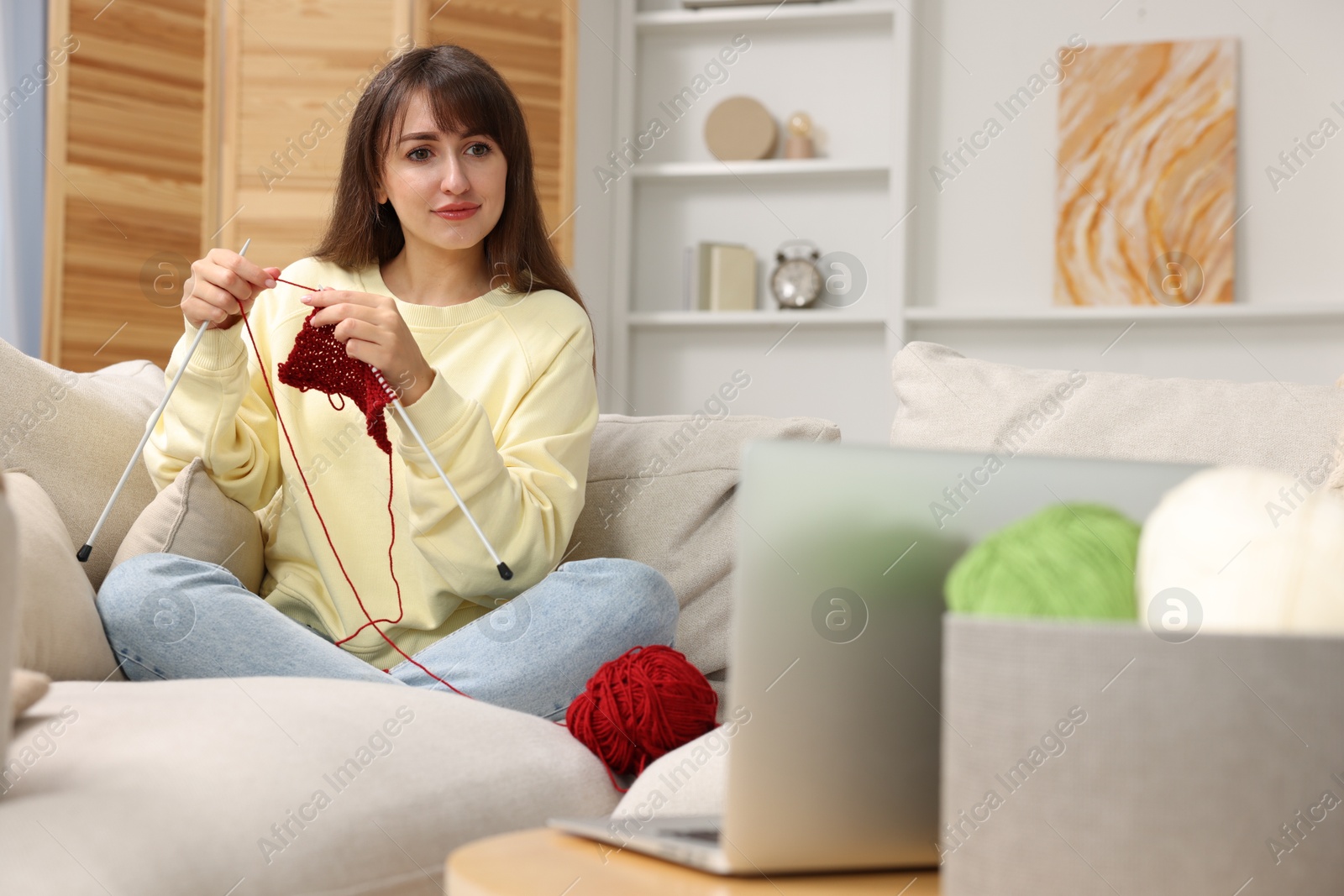 Photo of Beautiful woman learning to knit with online course at home