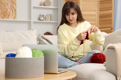 Photo of Beautiful woman learning to knit with online course at home