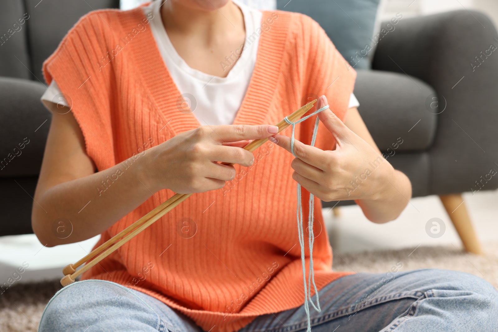 Photo of Woman knitting with needles at home, closeup