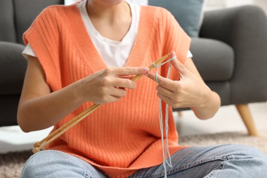 Woman knitting with needles at home, closeup