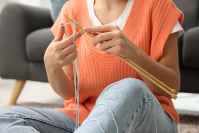 Woman knitting with needles at home, closeup