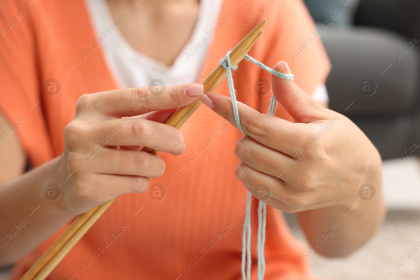 Photo of Woman knitting with needles at home, closeup