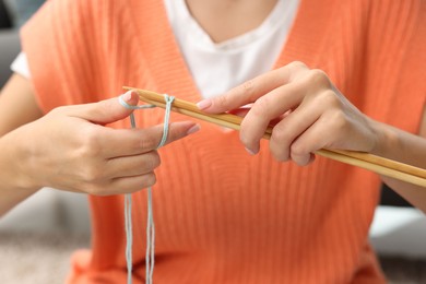 Woman knitting with needles at home, closeup