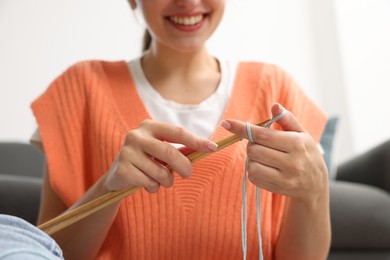 Woman knitting with needles at home, closeup