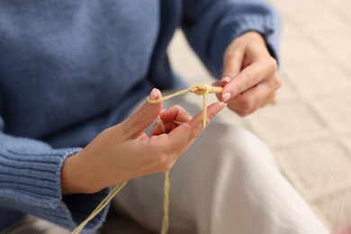 Woman knitting with needles at home, closeup