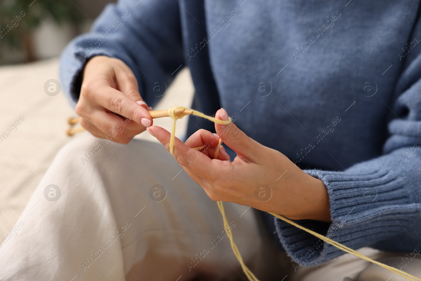 Photo of Woman knitting with needles at home, closeup