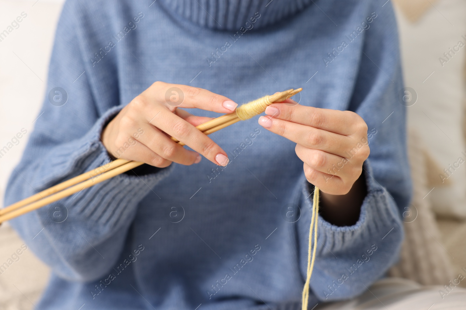 Photo of Woman knitting with needles at home, closeup