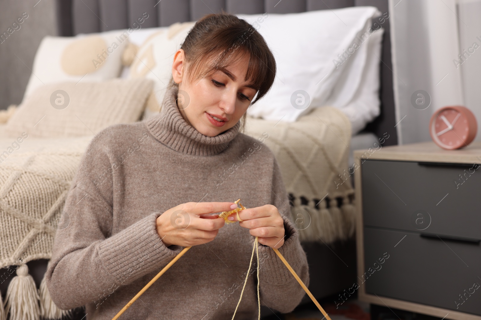 Photo of Beautiful woman knitting with needles at home